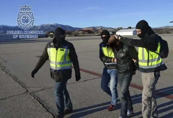 GRA344. CEUTA, 24/01/2015.- Fotograf&iacute;a facilitada por la Polic&iacute;a Nacional de uno de los cuatro presuntos terroristas detenidos en Ceuta -Farid Mohammed Al Lal y su hermano Mohammed y Anwar Alli Amzal y su hermano Rodouan- que es conducido por varios agentes para su traslado a Madrid en helic&oacute;ptero bajo importantes medidas de seguridad, incluida vigilancia a&eacute;rea. Los detenidos han sido trasladados a la capital bajo el mismo procedimiento que se hab&iacute;a aplicado en anteriores operaciones desarrolladas en la ciudad aut&oacute;noma. Un importante dispositivo policial ha participado en el traslado desde la barriada del Pr&iacute;ncipe hasta el helipuerto civil. EFE/-TFGP.