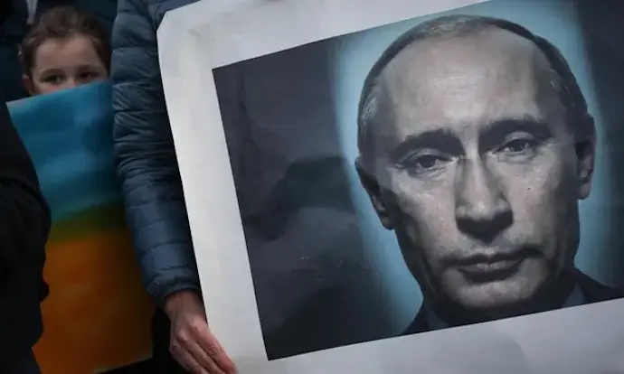 Una mujer sostiene una pancarta de Vladimir Putin mientras participa en una protesta por la paz en Lisboa, Portugal, el s&aacute;bado. Fotograf&iacute;a: Rodrigo Antunes / EFE