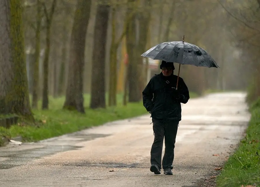 Una persona se refugia con un paraguas de la lluvia. / EP