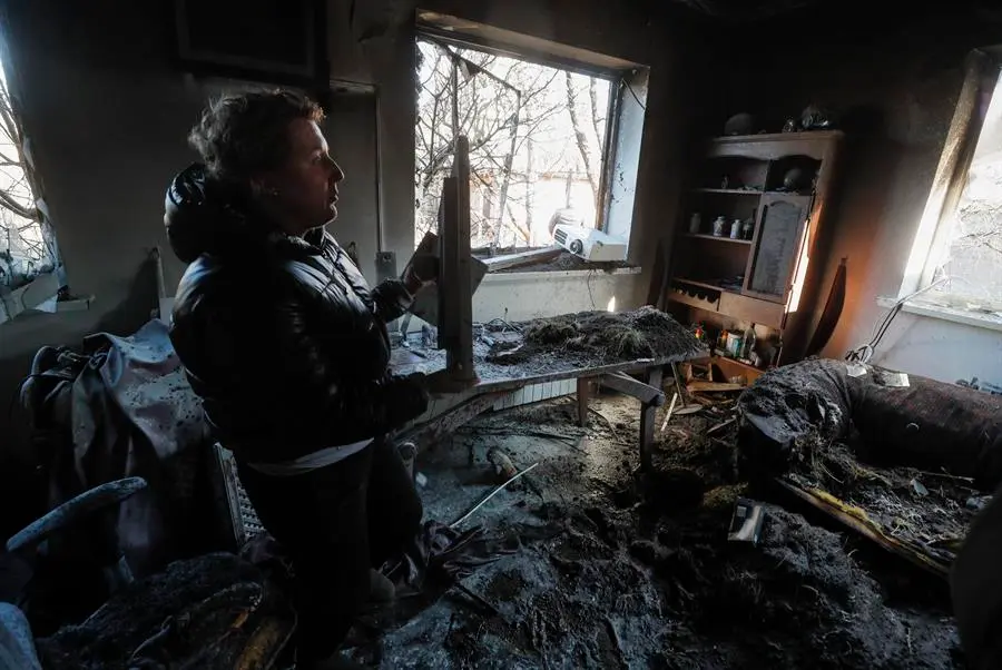 Un hombre recupera objetos del interior de un apartamento da&ntilde;ado tras un bombardeo nocturno en un pueblo de vacaciones en el distrito de Osokorky, en las afueras de Kiev (Ucrania), el 15 de marzo de 2022. EFE/EPA/SERGEY DOLZHENKO