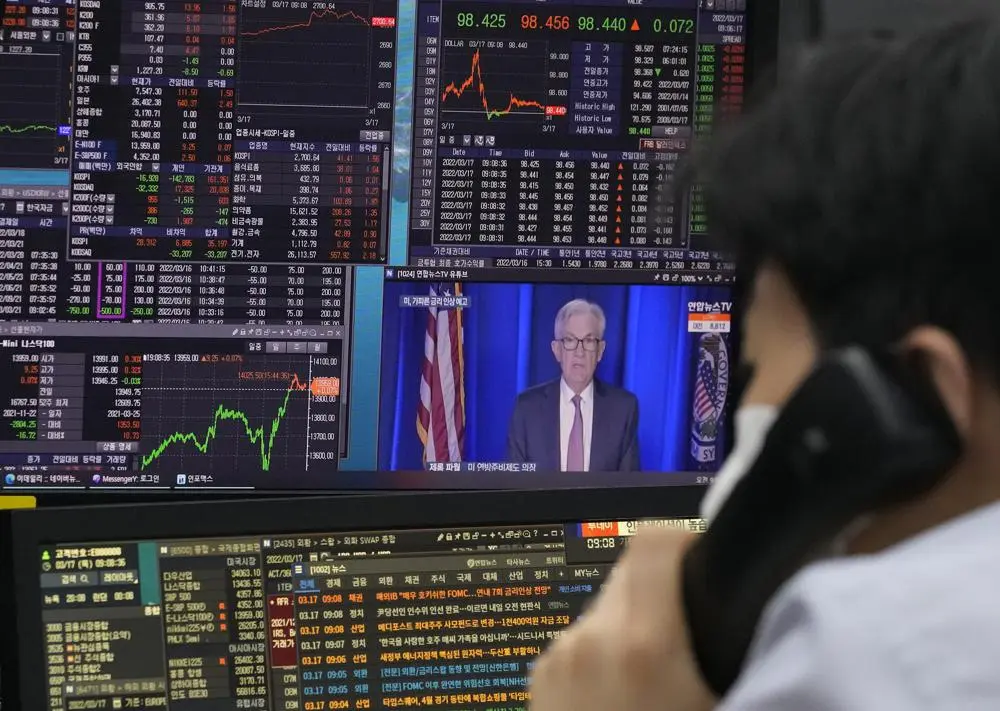 Un comerciante de divisas observa los monitores frente a las pantallas que muestran el &iacute;ndice de precios de acciones compuesto de Corea (KOSPI) y el tipo de cambio entre el d&oacute;lar estadounidense y el won surcoreano, a la derecha, en la sala de operaciones de divisas de la sede del KEB Hana Bank en Se&uacute;l, Sur. Corea, jueves 17 de marzo de 2022. Los precios de las acciones asi&aacute;ticas han subido por segundo d&iacute;a despu&eacute;s de que la Reserva Federal anunciara su primera subida de tipos de inter&eacute;s desde 2008 y China prometiera apoyo a sus sectores inmobiliario y de Internet. (Foto AP/Ahn Young-joon)