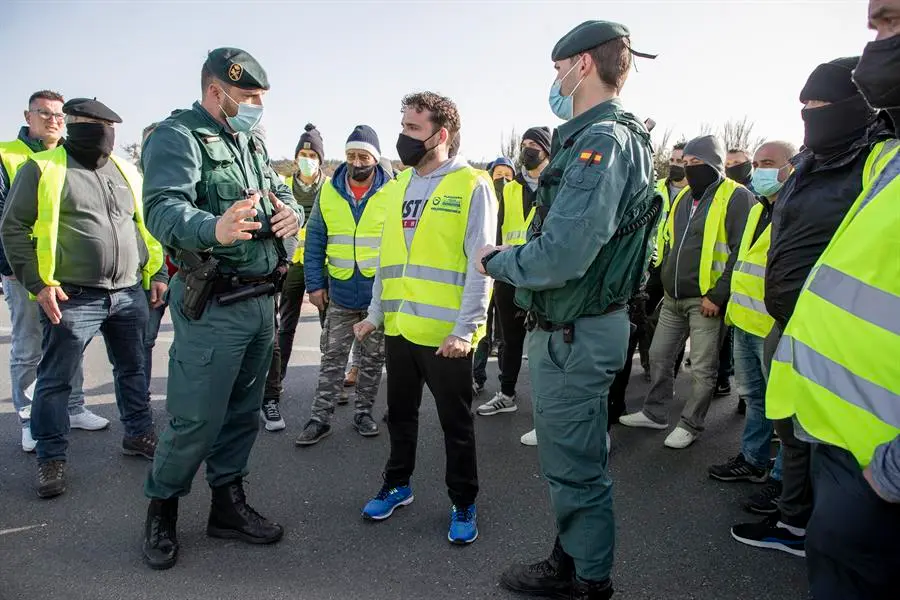 Agentes de la Guardia Civil dialogan con transportistas que cortaron este viernes durante aproximadamente media hora la A-6.