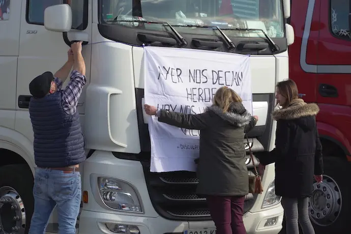 Varias personas pegan un cartel a un cami&oacute;n estacionado en la estaci&oacute;n de servicioAlberto Ruiz / Europa Press