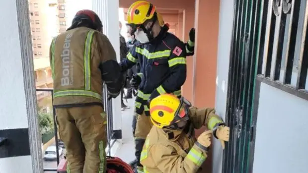 Imagen de los bomberos entrando en una vivienda de Benidorm donde encontraron el cad&aacute;ver de un hombre de 55 a&ntilde;os