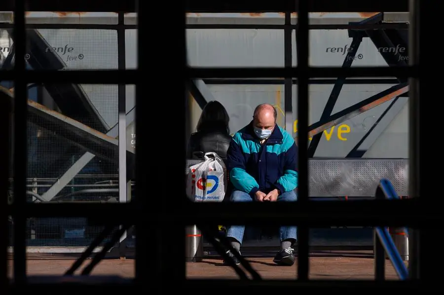 Dos personas esperan en la estaci&oacute;n de trenes de Torrelavega, este martes, en una jornada en que los trenes de Cercan&iacute;as ha estado parados desde la 5:00 hasta las 08:00 por una obras de mantenimiento y acumulan retrasos de 50 minutos. EFE/Pedro Puente Hoyos
