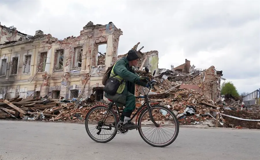Un habitante de J&aacute;rkov pasa en bicicleta delante de un edificio destruido por los ataques rusos. EFE/EPA/VASILIY ZHLOBSKY