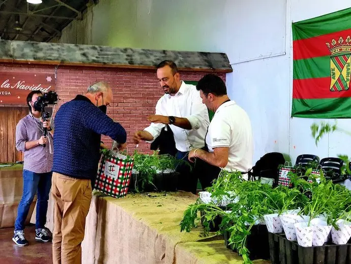 El alcalde Javier L&oacute;pez Estrada repartiendo tomates a los ciudadanos.