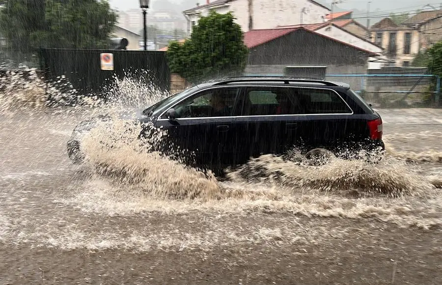 Un coche circula por una calle de Oviedo que se encuentra inundada tras las &uacute;ltimas lluvias registradas en la regi&oacute;n. Todoel Principado, salvo la franja litoral, se encuentra hoy en alerta amarilla ante el riesgo de fuertes tormentas y precipitaciones que pueden alcanzar los 15 litros en una hora a partir del mediod&iacute;a y que pueden presentarse tambi&eacute;n en forma de granizo. EFE/Paco Paredes