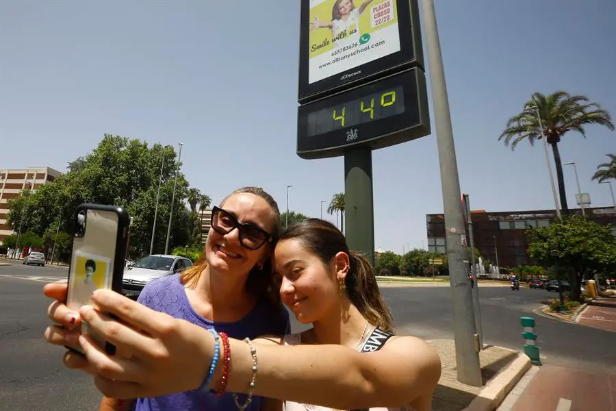 Varios turistas se fotograf&iacute;an junto a un term&oacute;metro que marca 44 grados, este domingo en C&oacute;rdoba. EFE/Salas