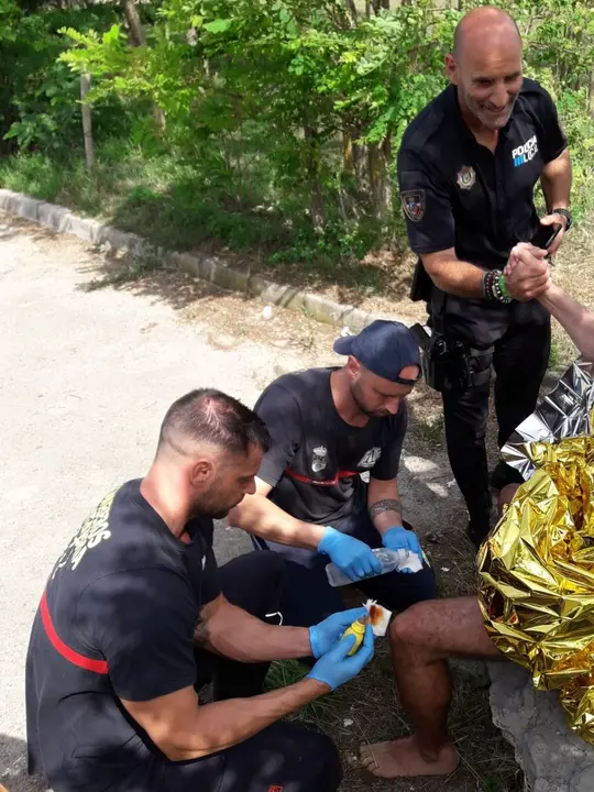 Los agentes junto al turista que acaba de salvar la vida.