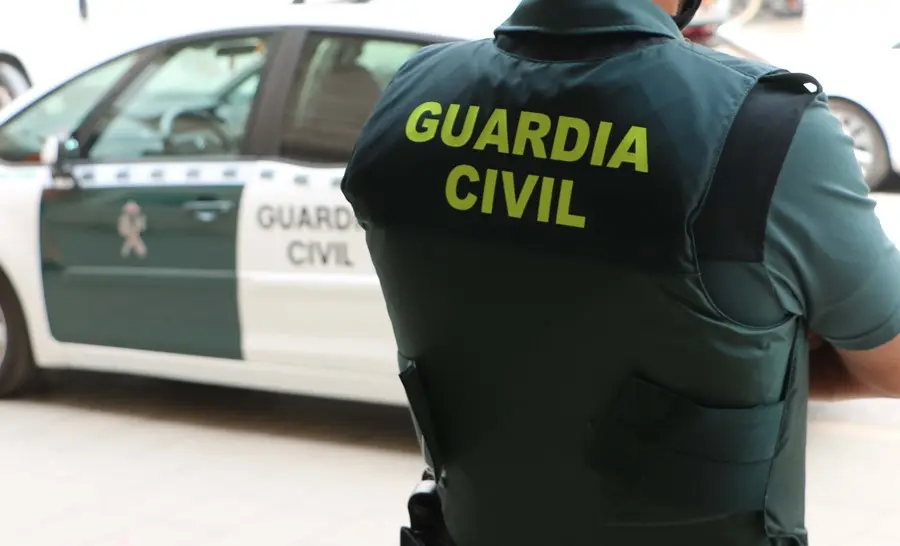 Un agente de la Guardia Civil, de espaldas, junto a un veh&iacute;culo oficial. Archivo.