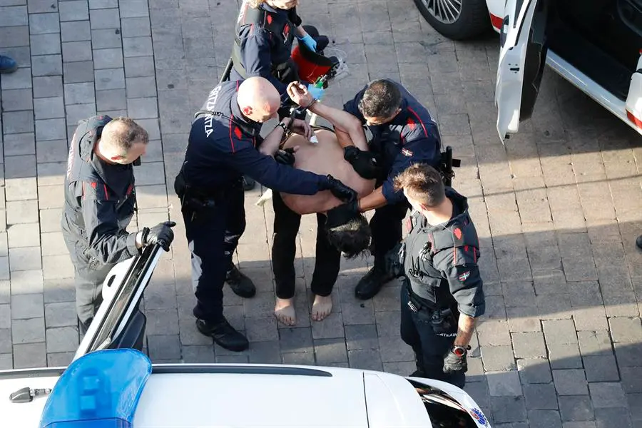El hombre que se hab&iacute;a atrincherado en su piso en el Casco Viejo de Vitoria es arrestado por agentes de la Ertzaintza, este domingo en Vitoria. La Ertzaintza ha desalojado el edificio por precauci&oacute;n, ya que el hombre portaba un hacha y ha llegado a amenazar con quemar la vivienda. EFE/David Aguilar