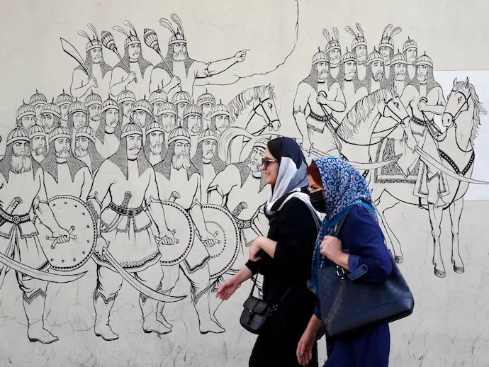 Mujeres iran&iacute;es pasan junto a una pintura mural en una calle de Teher&aacute;n, Ir&aacute;n. / efe/ ABEDIN TAHERKENAREH