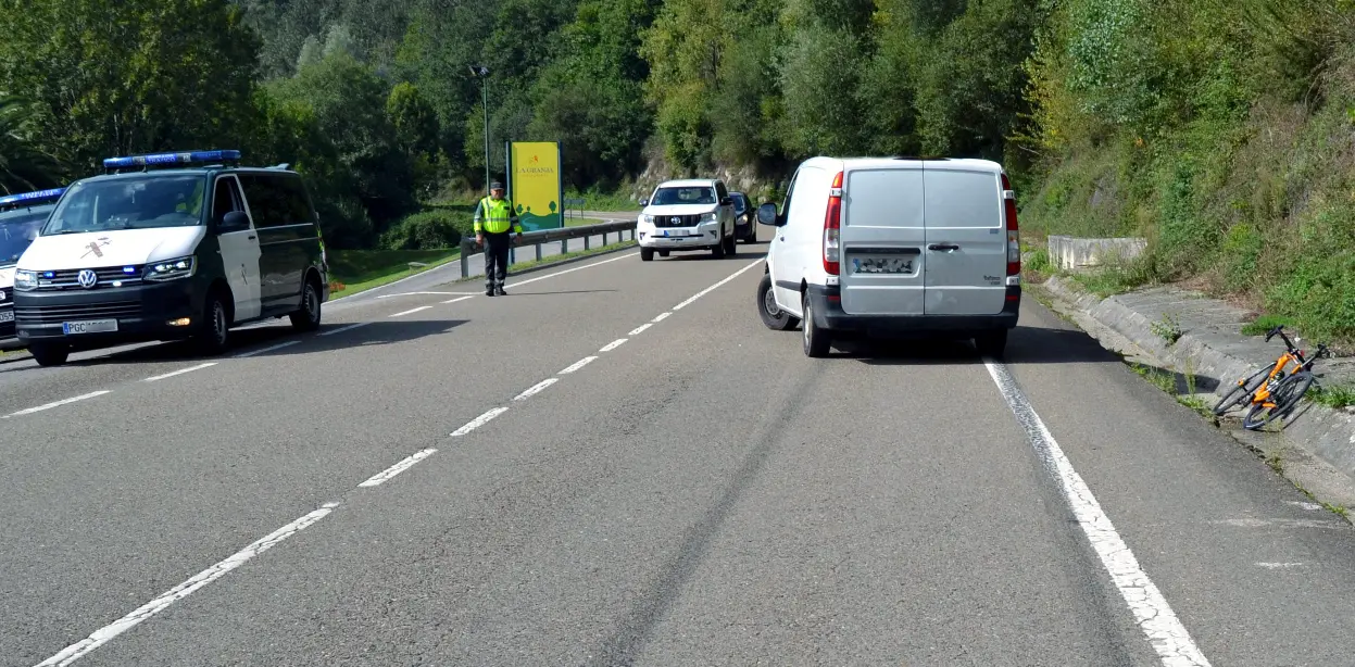 La Guardia Civil junto al veh&iacute;culo y la bicicleta tras el accidente. / OPC