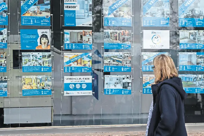 Una mujer observa el escaparate de una inmobiliaria en Santander. / Rom&aacute;n G. Aguilera