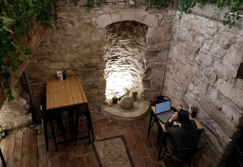 Una persona estudia con su ordenador en el s&oacute;tano de una bar del Casco Viejo de Pamplona que conserva restos arqueol&oacute;gicos de unas termas de la &eacute;poca romana (una de las dos que hab&iacute;a en Pamplona), que corresponden en concreto al muro del antiguo edificio de ba&ntilde;os p&uacute;blicos y al criptop&oacute;rtico o galer&iacute;a cubierta. EFE/ Jes&uacute;s Diges