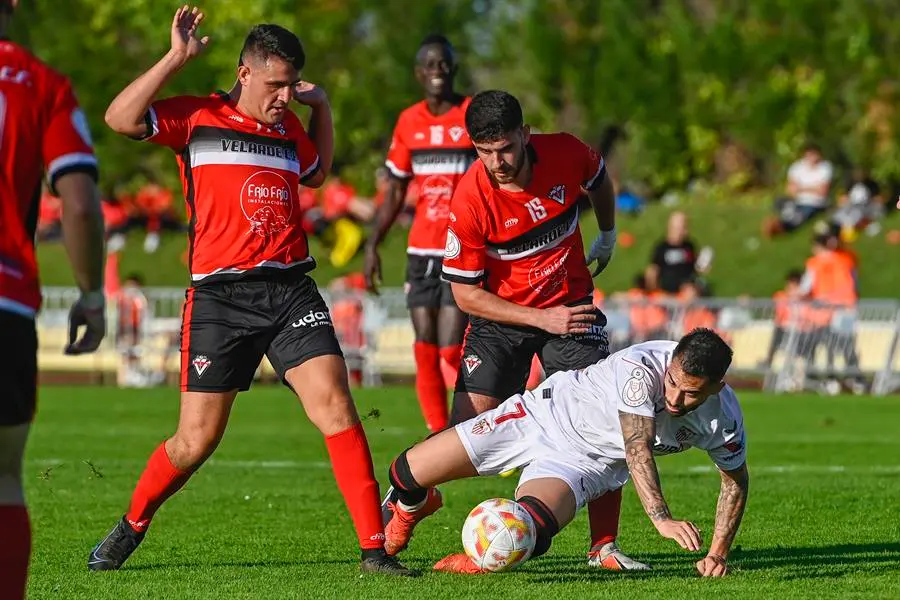 El delantero del Sevilla FC, Jes&uacute;s Fern&aacute;ndez Suso (c), disputa un bal&oacute;n a los jugadores del Velarde CF durante el partido de la Copa del Rey, este domingo, en las instalaciones deportivas municipales de La Maruca en la localidad c&aacute;ntabra de Malia&ntilde;o. EFE/Pedro Puente Hoyos