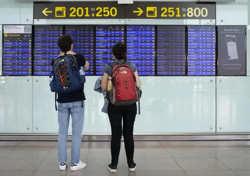 Dos viajeros consultaban los paneles con los vuelos programados en el aeropuerto de El Prat, en Barcelona, en la primera de las jornadas de huelga en la aerol&iacute;nea Vueling, el pasado 14 de noviembre. EFE/Enric Fontcuberta