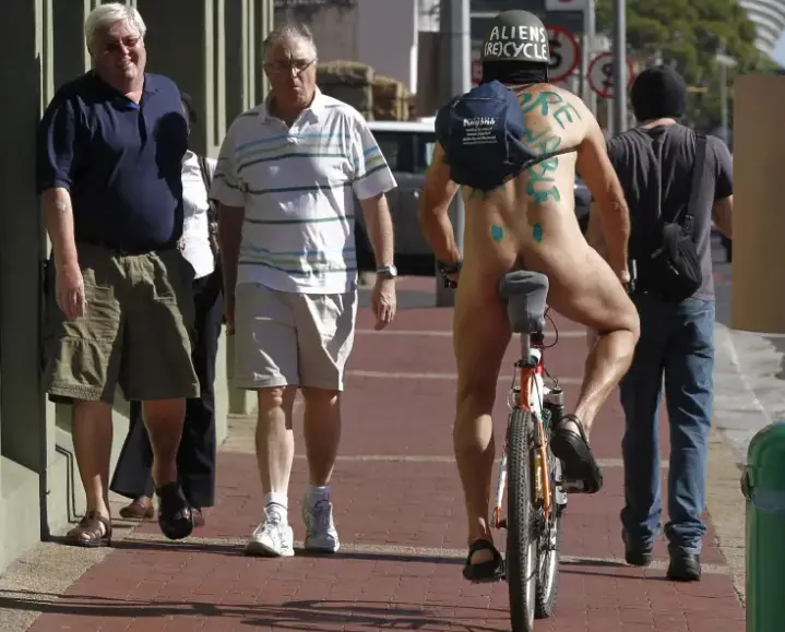 Dos hombres reaccionan al ver a un ciclista desnudo. EFE/Nic Bothma/Archivo