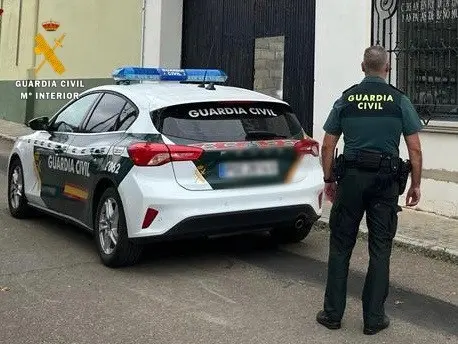 Vista de un agente y un coche de la Guardia Civil. E.P.