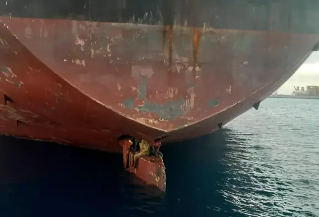 Foto tomada por Salvamento Mar&iacute;timo de los tres polizones sobre el tim&oacute;n del petrolero Alithini II en el puerto de Las Palmas de Gran Canaria el pasado 28 de noviembre. EFE/Salvamento Mar&iacute;timo