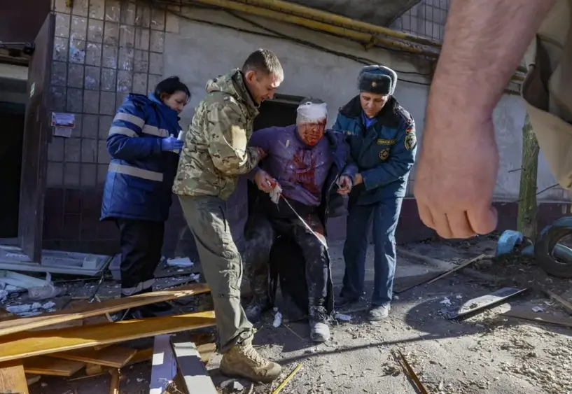 Varias personas ayudan a un hombre herido despu&eacute;s de que un cohete impactara en un edificio residencial en Donetsk, Ucrania. EFE/EPA/Sergei Ilnitsky