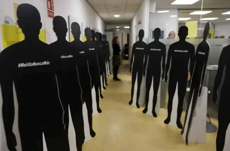 Un miembro de Amnist&iacute;a Internacional de pie junto con siluetas que representan a los migrantes muertos durante la presentaci&oacute;n del informe. EFE/Sergio P&eacute;rez
