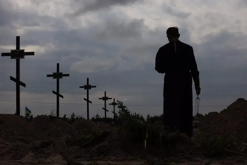 Un sacerdote ortodoxo bendec&iacute;a los restos de personas no identificadas que fueron asesinadas en el distrito de Bucha, al noroeste de Kiev, el pasado mes de agosto. EFE/EPA/Roman Pilipey