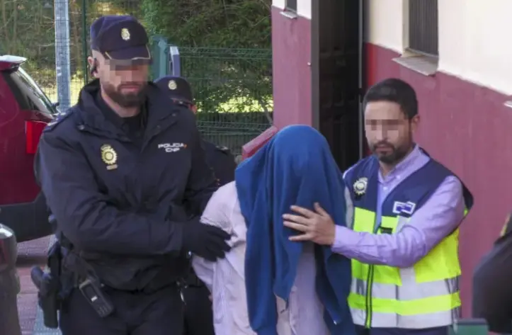 El presunto asesino de su exmujer en Dos Hermanas (Sevilla) es conducido este s&aacute;bado por la Polic&iacute;a Nacional a la vivienda donde se produjeron los hechos. EFE / Ferm&iacute;n Cabanillas