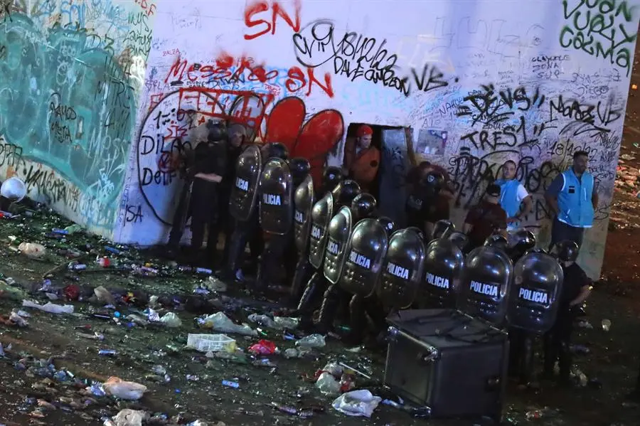 ntegrantes de la Polic&iacute;a Argentina forman una barrera durante los disturbios hoy, tras las celebraciones por el triunfo de la selecci&oacute;n en el Mundial Qatar 2022 en Buenos Aires (Argentina). Serios disturbios se registraron en la noche de este martes en los alrededores del Obelisco, en pleno centro de Buenos Aires, tras los multitudinarios festejos para recibir a la selecci&oacute;n argentina de f&uacute;tbol, vencedora en Qatar 2022. EFE/Ra&uacute;l Mart&iacute;nez