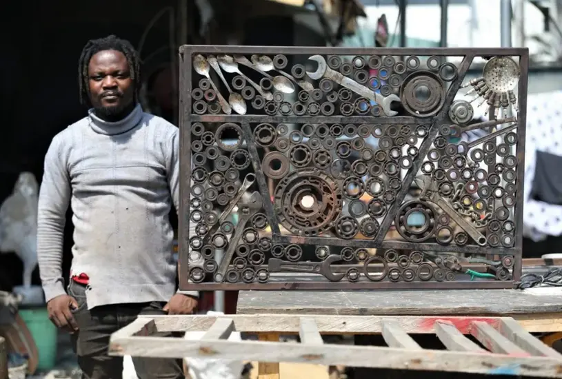 El artista Abinoro Akporode Collins junto a una de sus obras. EFE/Akintunde Akinleye