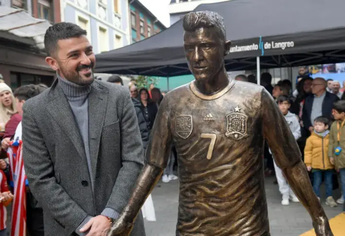 El exfutbolista David Villa observa la estatua en su honor descubierta en La Felguera (Asturias). EFE/ Eloy Alonso