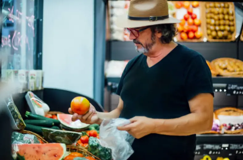 Un cliente en un supermercado coge productos en la zona de fruter&iacute;a. / E. PRESS
