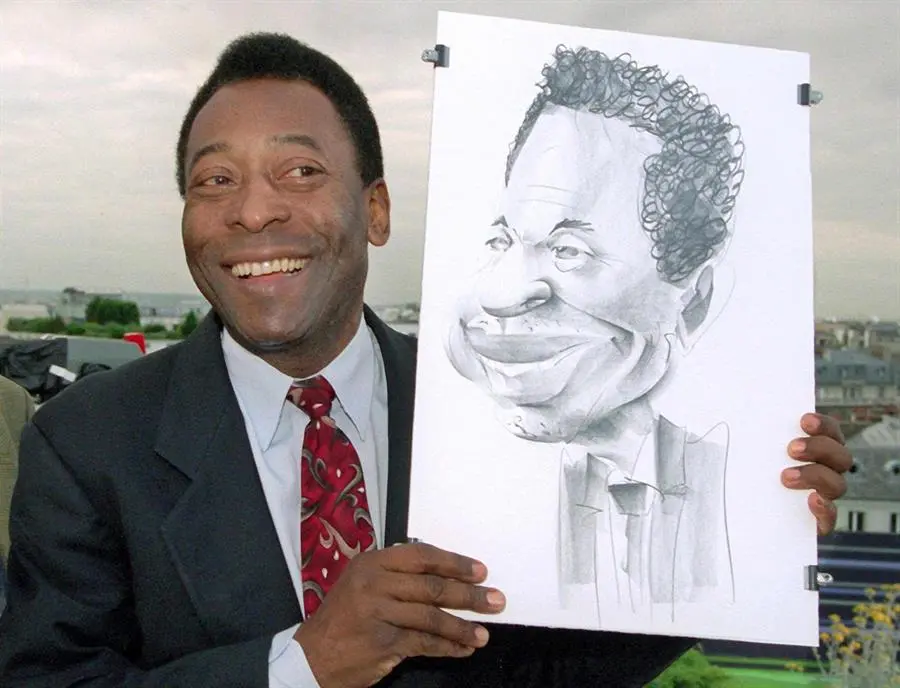 La leyenda del f&uacute;tbol brasile&ntilde;o Pel&eacute; posa con una caricatura de s&iacute; mismo en el estudio del canal de televisi&oacute;n alem&aacute;n ZDF en la azotea de un hotel, en Par&iacute;s, Francia, el 12 de junio de 1998 (reeditado el 29 de diciembre de 2022). Seg&uacute;n su agente, Pel&eacute;, cuyo nombre propio es Edson Arantes do Nascimento, ha fallecido el 28 de diciembre de 2022 a los 82 a&ntilde;os. (Brasil, Francia) EFE/EPA/PETER KNEFFEL