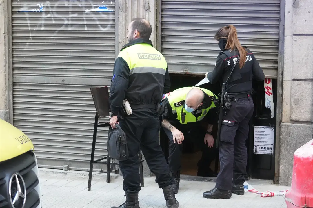 Dos agentes de la Polic&iacute;a Municipal y una de la Ertzaintza salen de la taberna Hiargi, donde ha tenido lugar el suceso. H. Bilbao