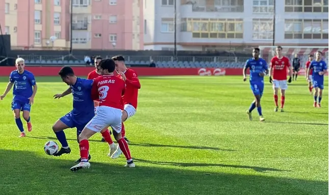 Los jugadores del Laredo intentan quitar el bal&oacute;n a uno del Ourense en campo San Lorenzo.