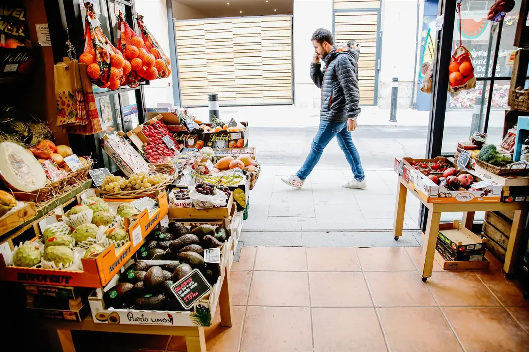 Una persona pasa por delante de una fruter&iacute;a. E.P. / Carlos Luj&aacute;n