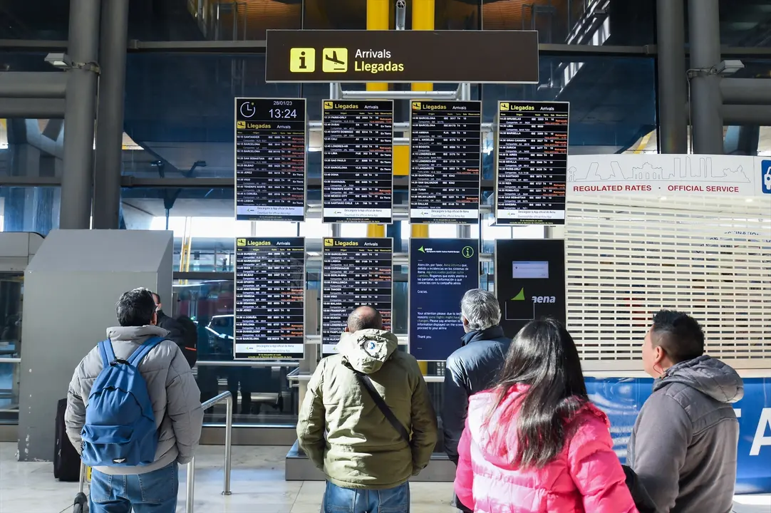 Varias personas observan los paneles informativos que anuncian retrasos de llegadas en algunos vuelos de Iberia en la Terminal 4 del Aeropuerto Madrid-Barajas Adolfo Su&aacute;rez. E.P. / Gustavo Valiente