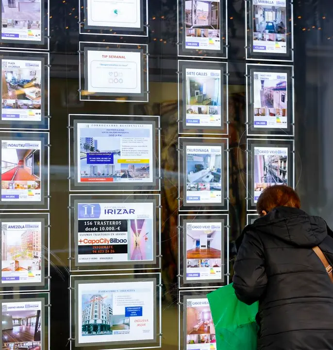 Una mujer observa en una inmobiliaria la oferta de viviendas. / Luis Tejido
