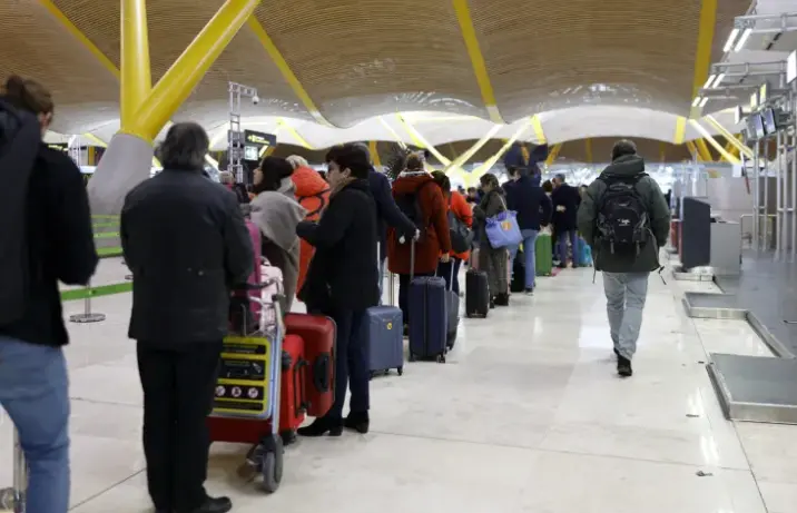 Varias personas hacen cola para facturar tras el fallo de conectividad en los sistemas de Iberia. EFE / Rodrigo Jim&eacute;nez