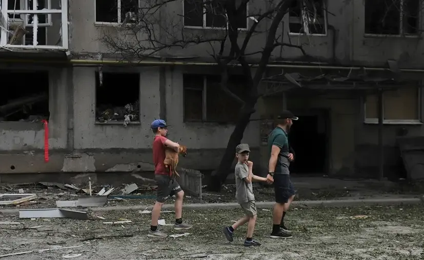 Varias personas en una calle de Bajmut, en la regi&oacute;n de Donetsk, en la que se aprecian los efectos de los bombardeos rusos. EFE