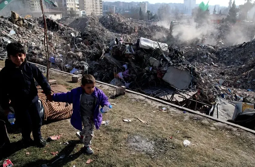 Unos ni&ntilde;os juegan junto a un solar de edificios derrumbados tras el terremoto en Kahramanmaras, Turqu&iacute;a. EFE / Tolga Bozoglu