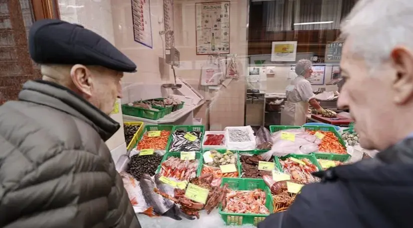 Dos personas observan el g&eacute;nero y precios de una pescader&iacute;a en Bilbao. EFE/Luis Tejido