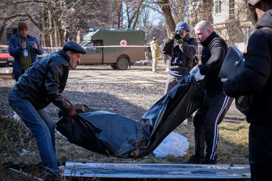 Personal de servicios comunales retira el cuerpo de una v&iacute;ctima mortal de un ataque con misiles rusos en un edificio residencial en Kramatorsk, cercana a Bajmut. EFE / YEVGEN HONCHARENKO