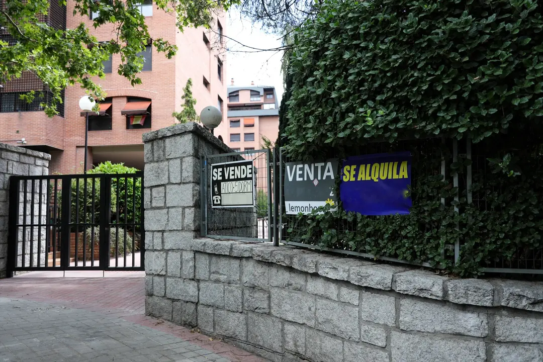 En la valla de una urbanizaci&oacute;n, se ven colgados dos carteles de 'Se vende piso' y uno de 'Se alquila'. EP / Jes&uacute;s Hell&iacute;n