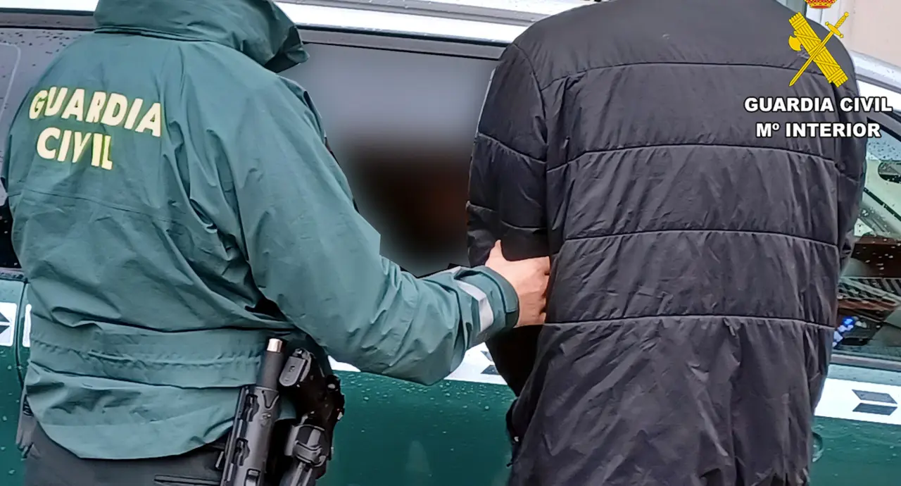 Un Guardia Civil custodia al detenido por el alunizaje.