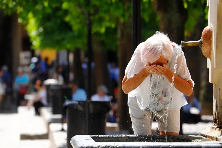 Una mujer se refresca en una fuente debido al calor sofocante. / A.E.