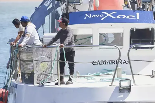 Varias personas en el barco gallego del que cay&oacute; el pescador desaparecido. / C&eacute;sar Ortiz