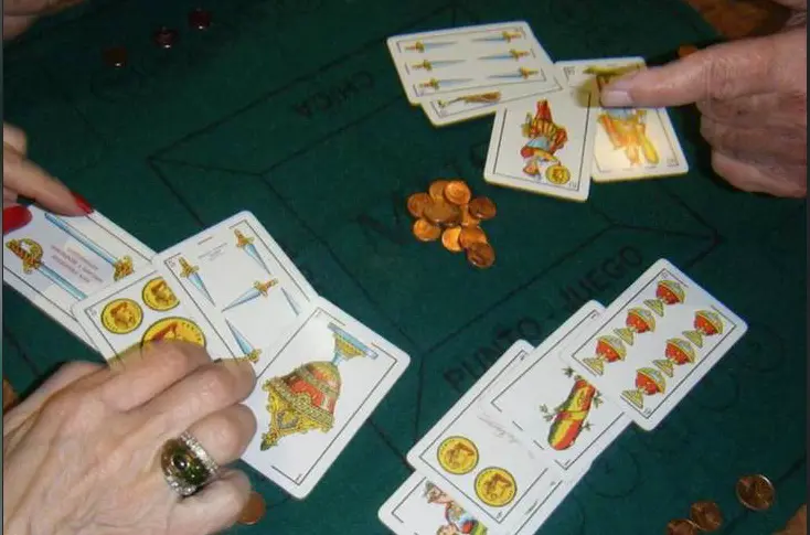 Varias personas jugando al mus.