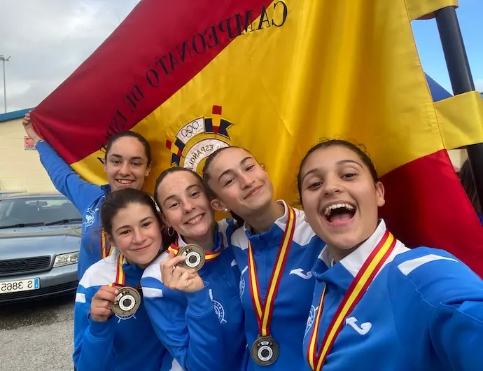 De derecha a izquierda (de m&aacute;s cerca a m&aacute;s lejos): Raquel Salazar, Sandra Santander, Manuela Narciso, Deva Campuzano y Jimena Fern&aacute;ndez, con la medalla de oro y la bandera de campeonas de Espa&ntilde;a.